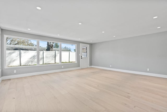 unfurnished room featuring light wood-style floors, recessed lighting, and baseboards