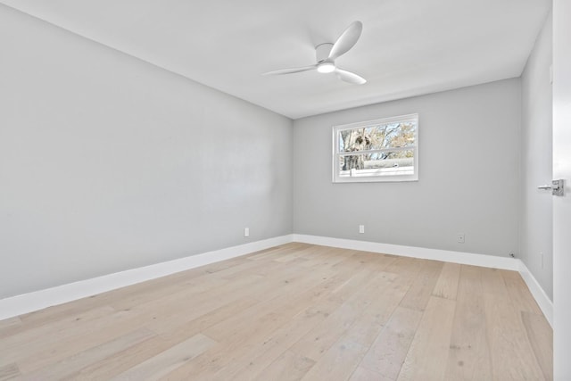 empty room with a ceiling fan, light wood-type flooring, and baseboards