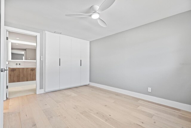 unfurnished bedroom with visible vents, light wood-style flooring, a ceiling fan, connected bathroom, and baseboards