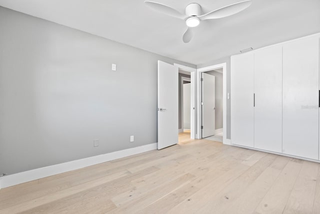 unfurnished bedroom with a ceiling fan, light wood-style flooring, and baseboards