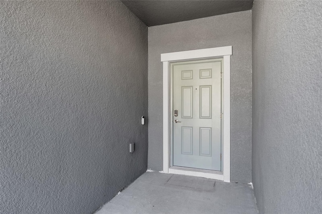 view of exterior entry with stucco siding