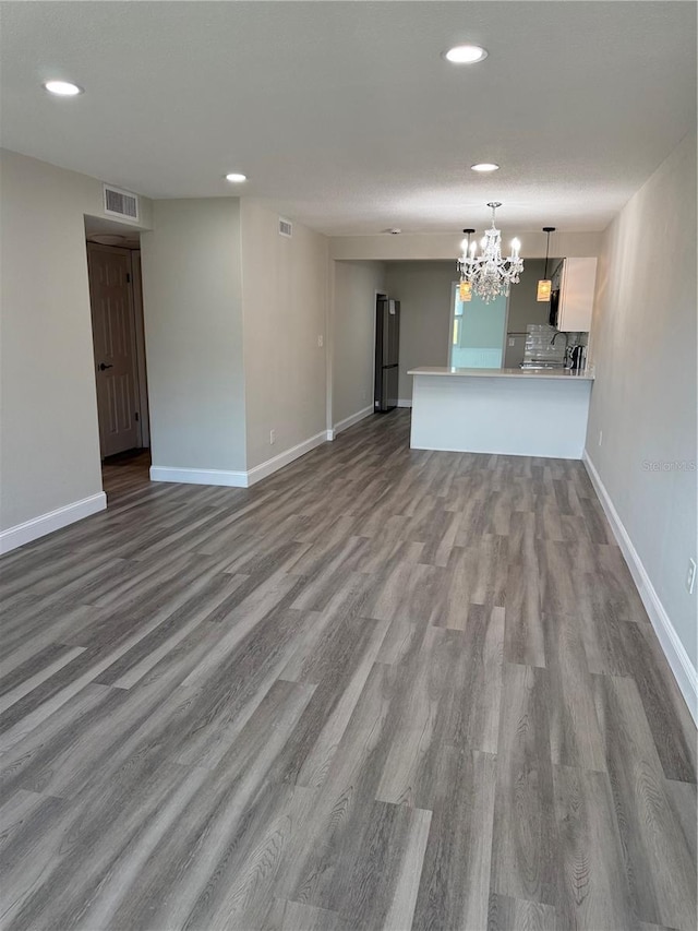 1000 49th St N Unit 309, Saint Petersburg, FL 33710 - unfurnished living room with baseboards, visible vents, wood finished floors, and recessed lighting