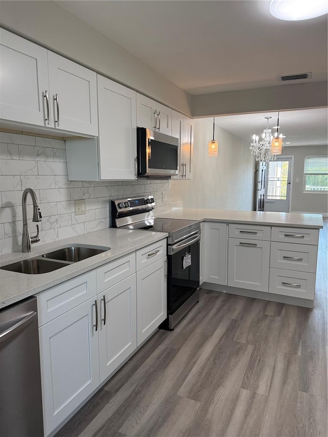 1000 49th St N Unit 309, Saint Petersburg, FL 33710 - kitchen featuring a peninsula, a sink, visible vents, white cabinets, and appliances with stainless steel finishes