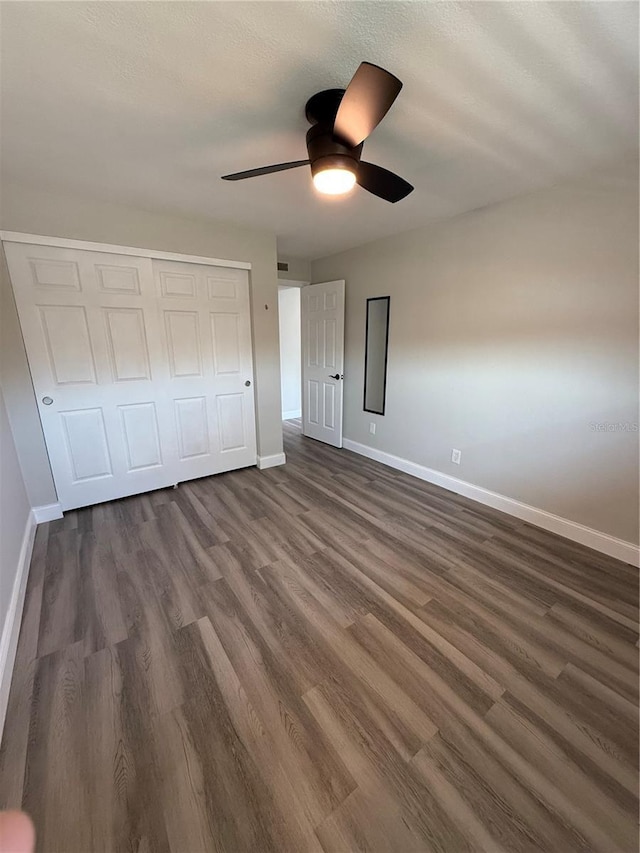 1000 49th St N Unit 309, Saint Petersburg, FL 33710 - unfurnished bedroom featuring a closet, dark wood finished floors, baseboards, and ceiling fan
