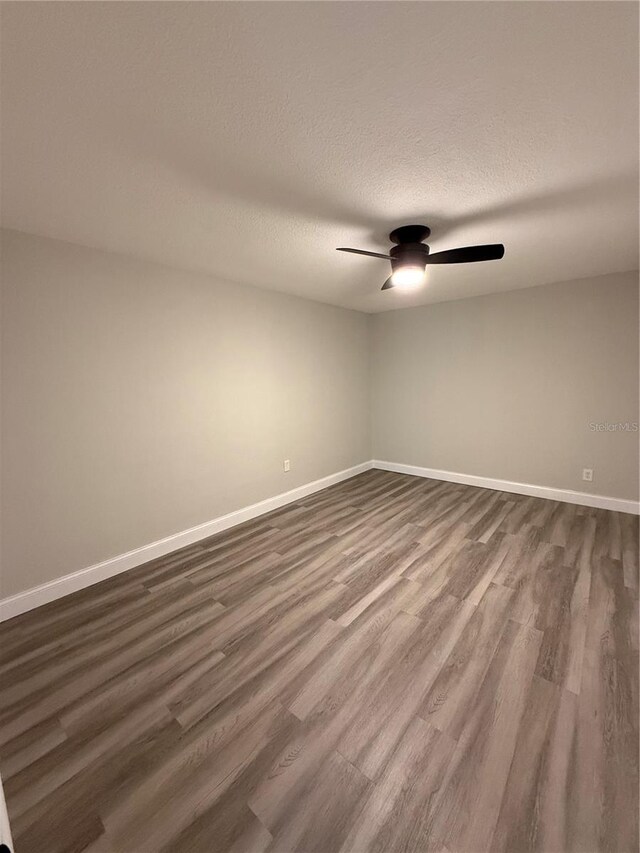 1000 49th St N Unit 309, Saint Petersburg, FL 33710 - spare room featuring a ceiling fan, dark wood-type flooring, a textured ceiling, and baseboards