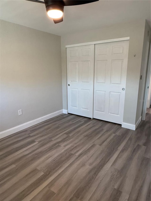 1000 49th St N Unit 309, Saint Petersburg, FL 33710 - unfurnished bedroom featuring dark wood-style floors, a ceiling fan, baseboards, and a closet