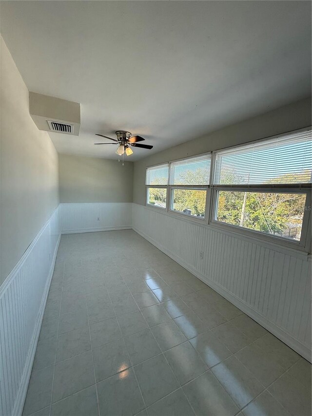 1000 49th St N Unit 309, Saint Petersburg, FL 33710 - unfurnished room featuring wainscoting, visible vents, ceiling fan, and tile patterned floors