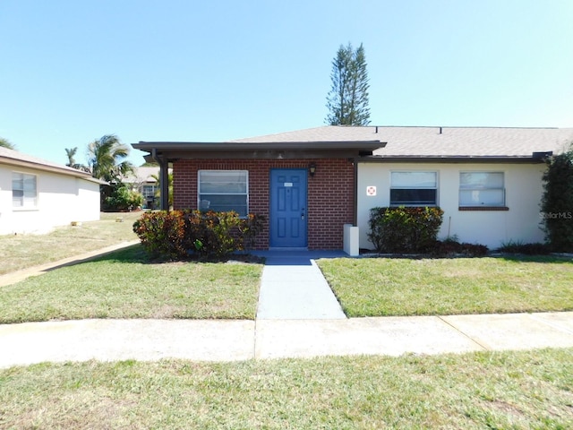 ranch-style house with brick siding and a front lawn