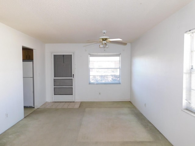 spare room featuring a ceiling fan and a textured ceiling