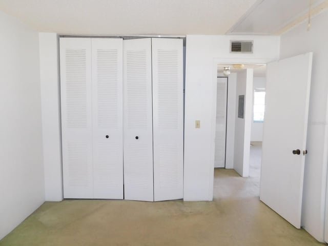 unfurnished bedroom with a closet, visible vents, and light colored carpet