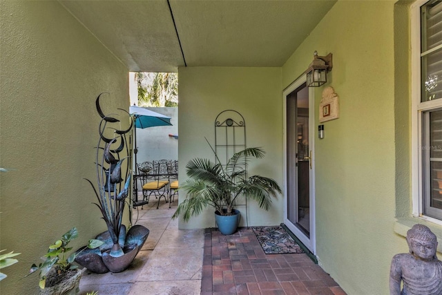 doorway to property featuring a patio area and stucco siding