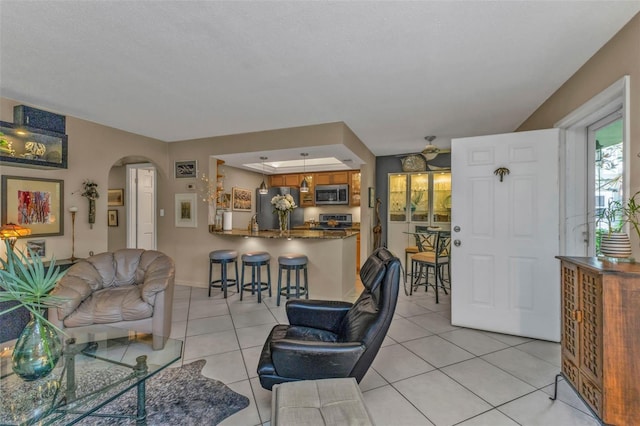 living room with arched walkways and light tile patterned flooring