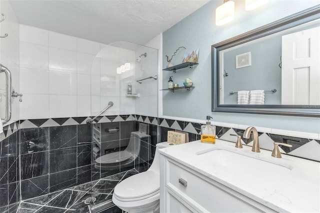 full bath featuring toilet, vanity, tile walls, tiled shower, and wainscoting