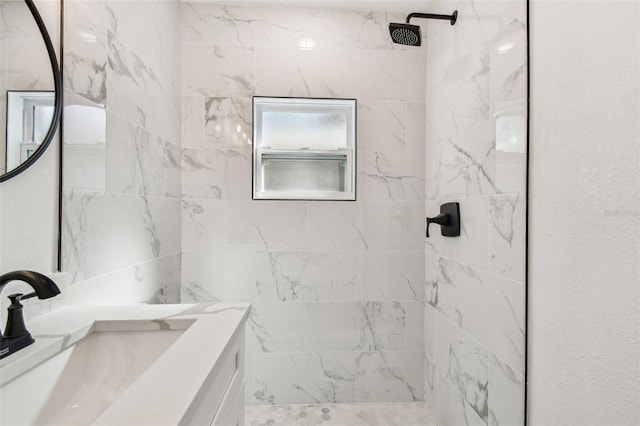 bathroom featuring tiled shower and vanity