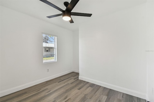 empty room with wood finished floors, a ceiling fan, and baseboards