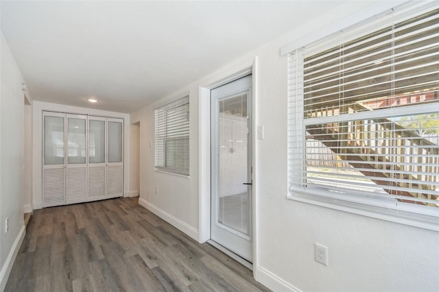 entryway with baseboards and wood finished floors