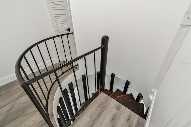 stairway featuring wood finished floors and baseboards