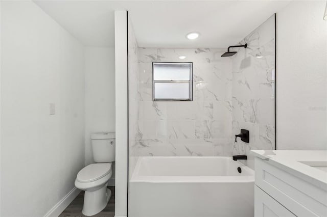 bathroom featuring baseboards, toilet, wood finished floors, vanity, and shower / washtub combination