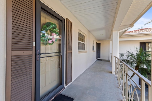 property entrance featuring a tile roof and stucco siding