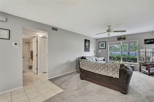 living area with light tile patterned floors, light colored carpet, visible vents, ceiling fan, and a textured ceiling