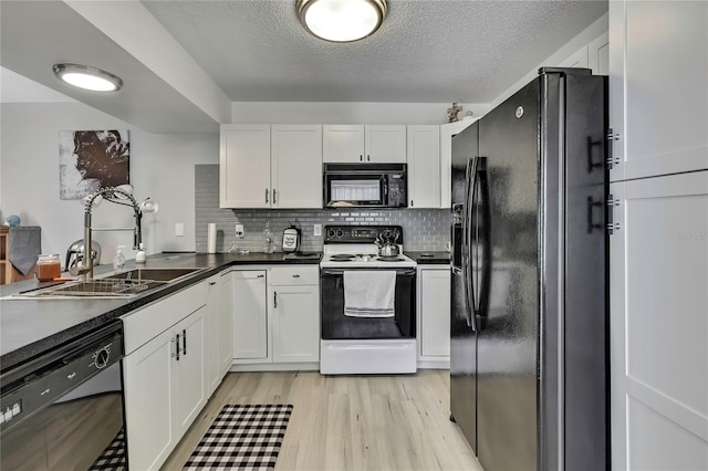 kitchen with light wood-style floors, white cabinetry, a sink, and black appliances