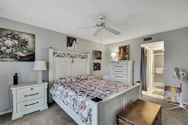 bedroom with light carpet, visible vents, a ceiling fan, and ensuite bathroom