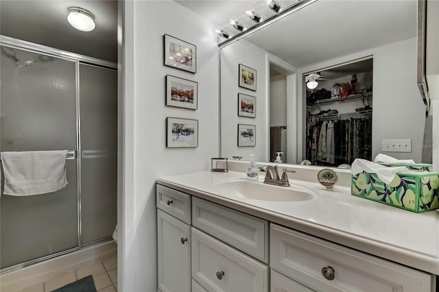 full bath featuring toilet, tile patterned floors, a spacious closet, vanity, and a shower stall