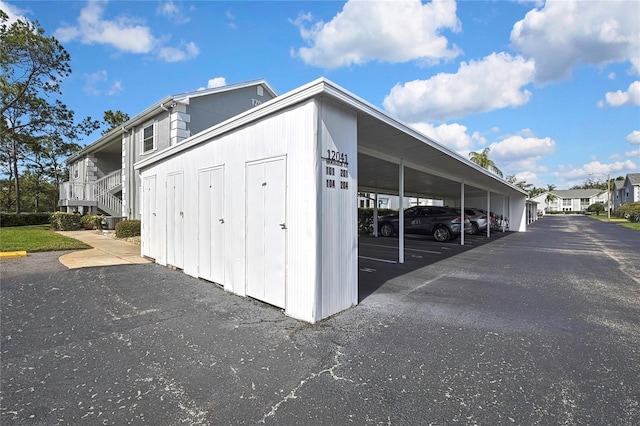 view of outdoor structure with covered parking and a residential view