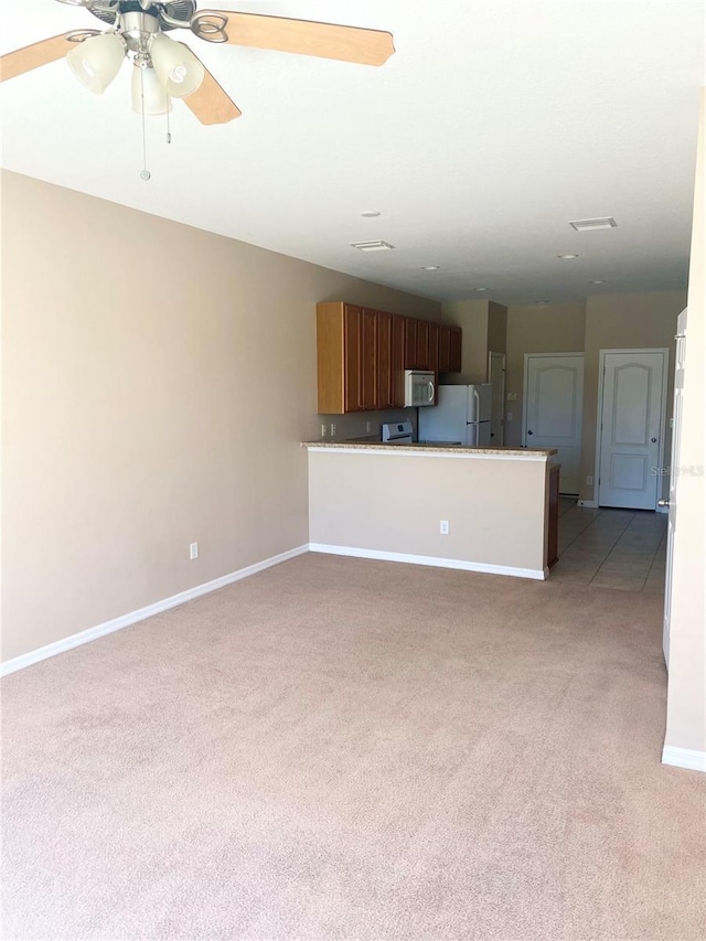 unfurnished living room featuring light carpet, ceiling fan, and baseboards