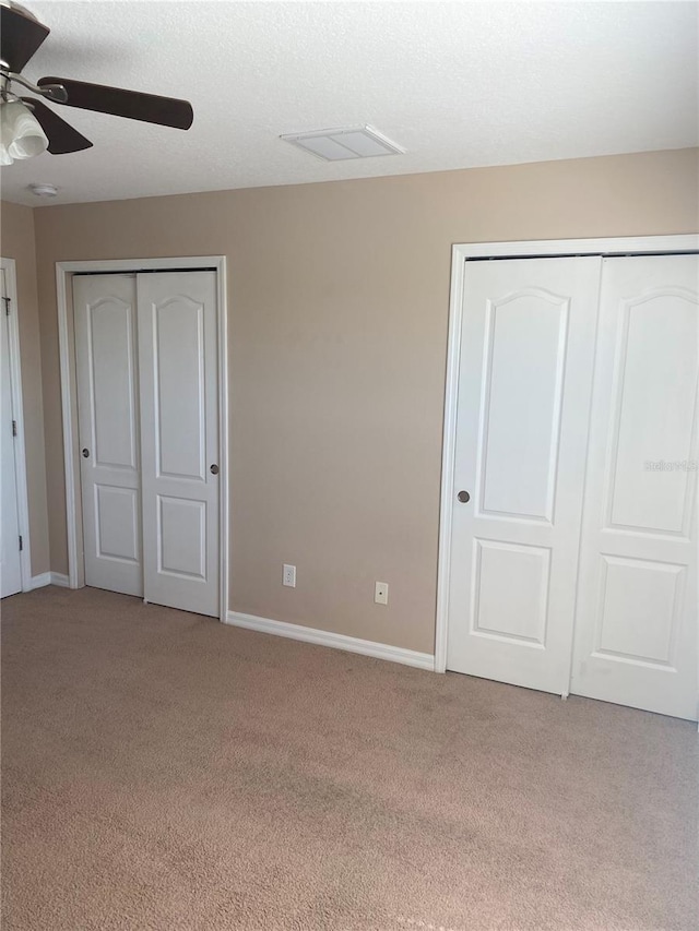 unfurnished bedroom with carpet flooring, visible vents, baseboards, and a textured ceiling