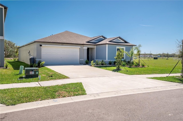 single story home featuring an attached garage, a shingled roof, concrete driveway, and a front yard