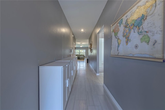 hallway featuring visible vents and baseboards