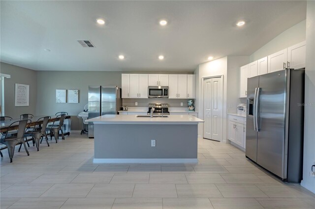 kitchen featuring light countertops, visible vents, appliances with stainless steel finishes, white cabinets, and a sink