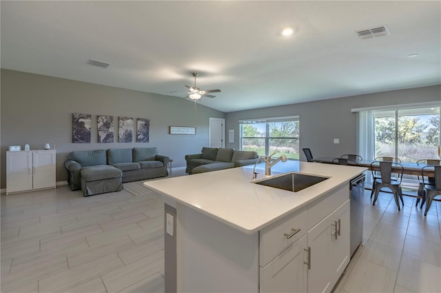 kitchen with lofted ceiling, dishwasher, visible vents, and a sink