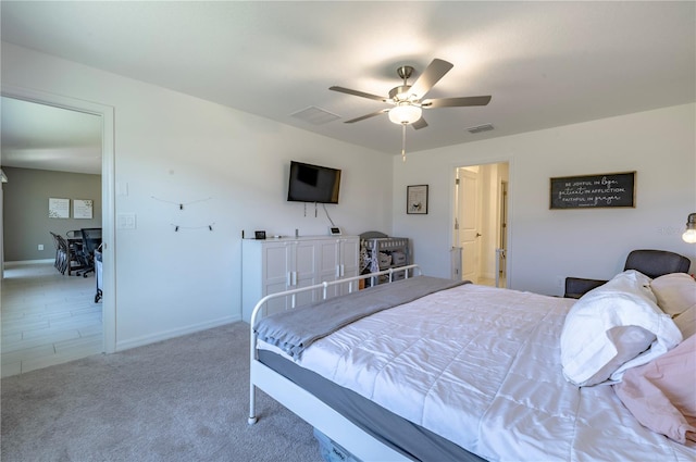 carpeted bedroom featuring ceiling fan, visible vents, and baseboards