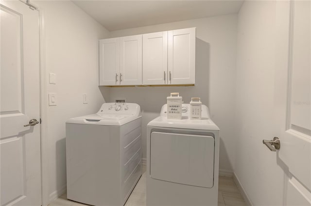 laundry room featuring independent washer and dryer, cabinet space, and baseboards