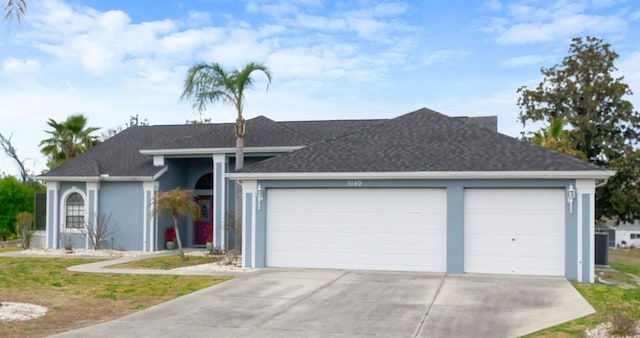 single story home featuring a garage, concrete driveway, and stucco siding