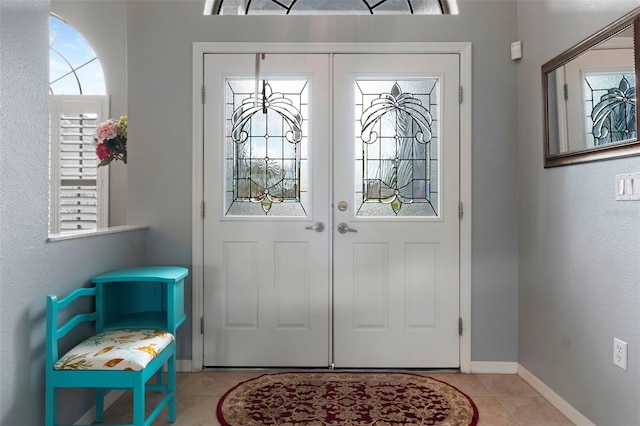 entryway featuring a healthy amount of sunlight, tile patterned flooring, baseboards, and french doors