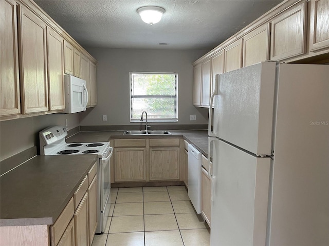 kitchen featuring light tile patterned floors, light brown cabinets, white appliances, a sink, and dark countertops