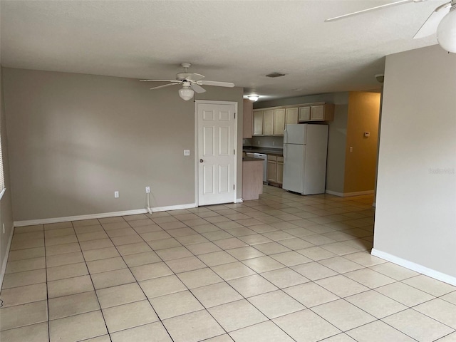 unfurnished room with ceiling fan, light tile patterned floors, and baseboards