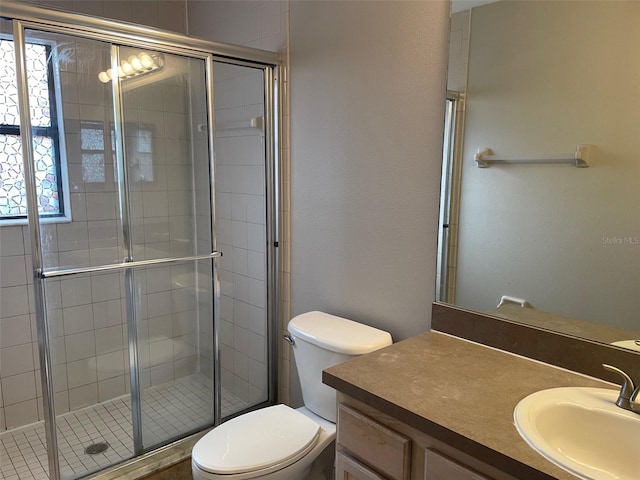 bathroom with a wealth of natural light, a stall shower, vanity, and toilet