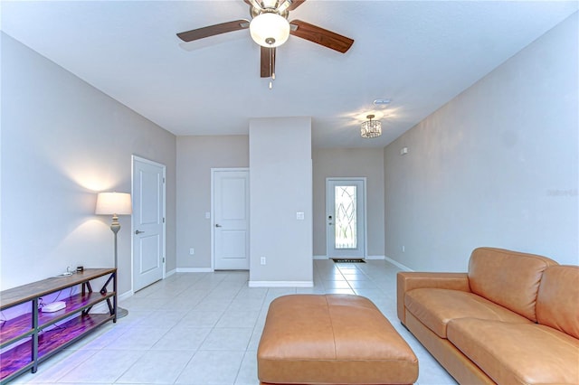 living room with light tile patterned floors, ceiling fan, and baseboards