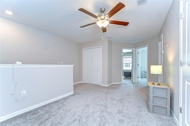 unfurnished bedroom with a closet, visible vents, carpet flooring, a textured ceiling, and baseboards