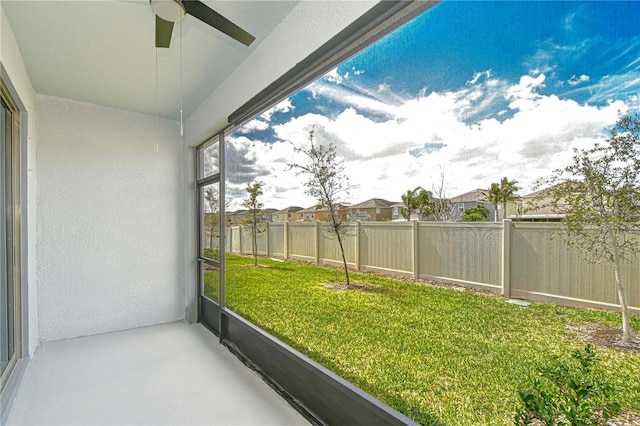 unfurnished sunroom with a ceiling fan