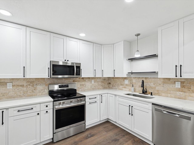 kitchen featuring a sink, decorative backsplash, stainless steel appliances, white cabinetry, and open shelves