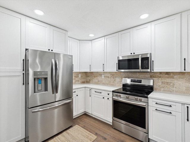 kitchen with white cabinetry, light countertops, decorative backsplash, and stainless steel appliances