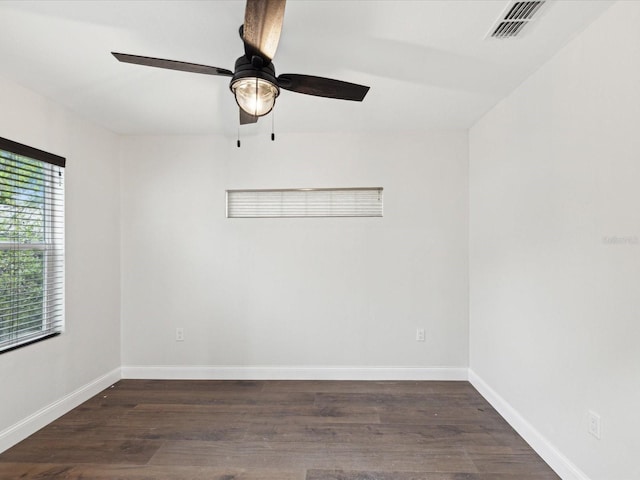 empty room with ceiling fan, visible vents, baseboards, and wood finished floors