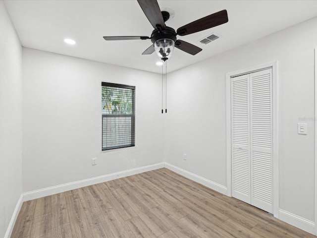 unfurnished bedroom with light wood-style floors, visible vents, a closet, and baseboards