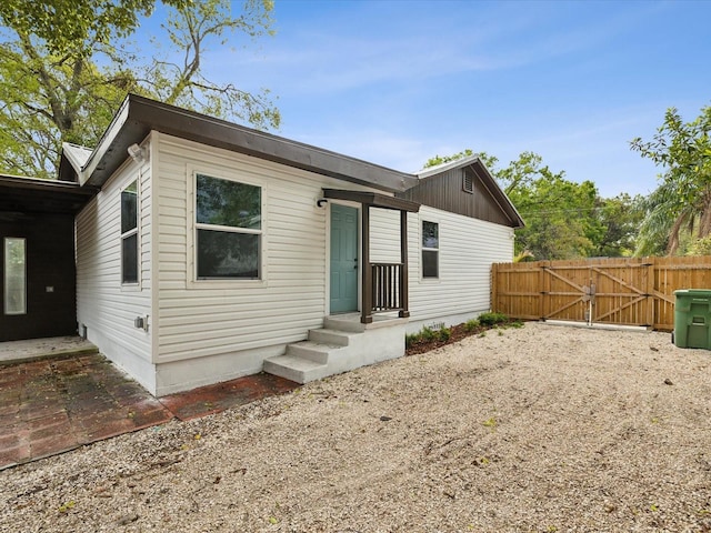 view of front of house with a patio, fence, and a gate