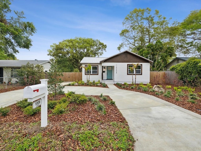 ranch-style house with fence and metal roof